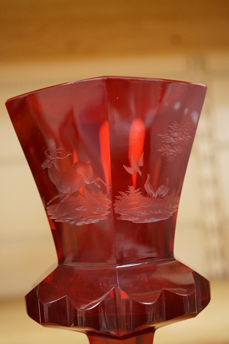 A 19th century Bohemian engraved ruby glass goblet, a similar amethyst and clear overlaid glass vase and an enamelled amethyst glass goblet, largest 15cm high